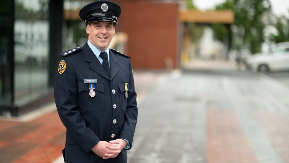 Michael Prior - portrait of a man in an official blue uniform with a hat on