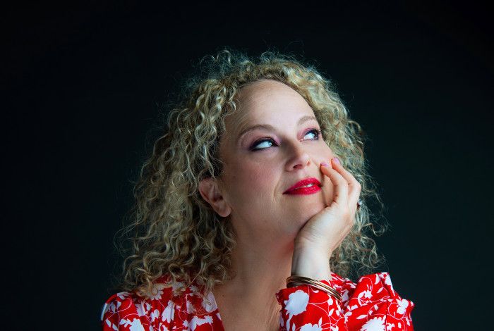 Blonde woman in red and white dress, looking away from the camera