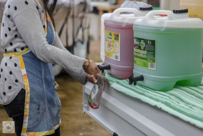 Roving Refills owner filling up their reusable container with cleaning products from a bulk container.
