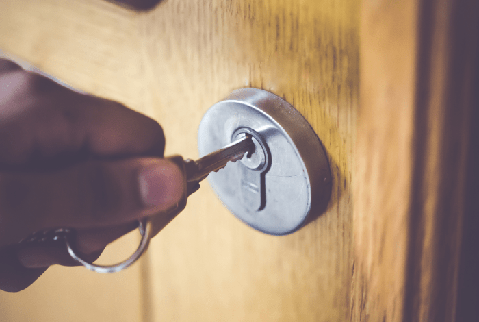 a person putting a key in a lock on a door