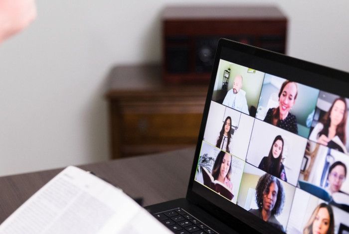 Person reading to nine person online call. 