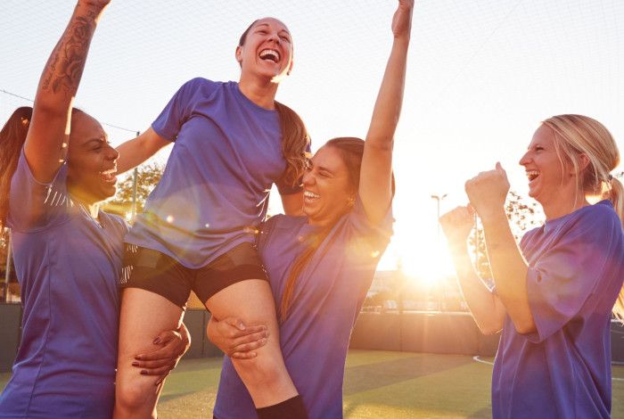 Group of women in soccer uniforms celebrating