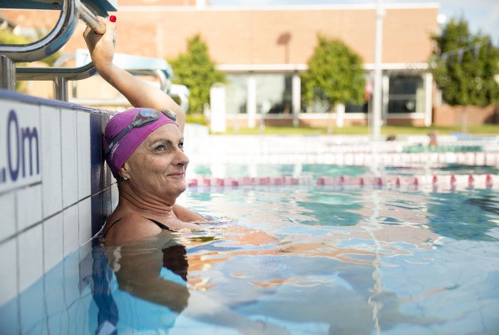 Women sitting in pool smiling