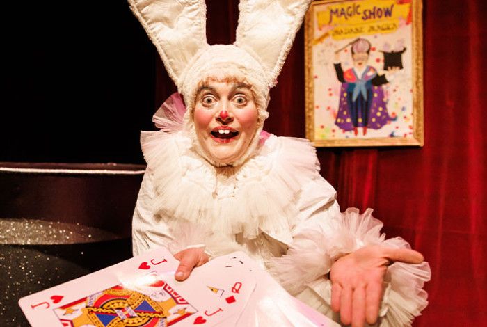 Person dressed as rabbit holding giant playing cards