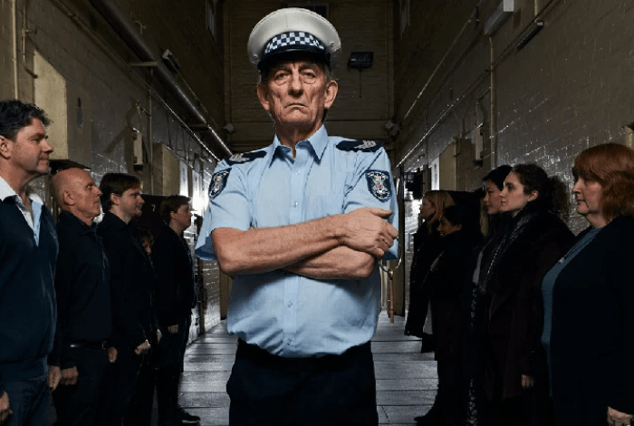 prison guard standing with crossed arms.