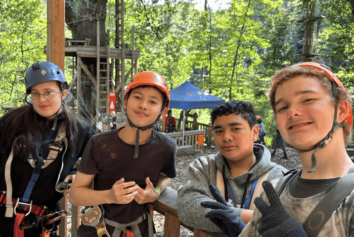 young people smiling at treetops