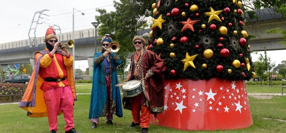 Three Musicians playing instruments in a park.