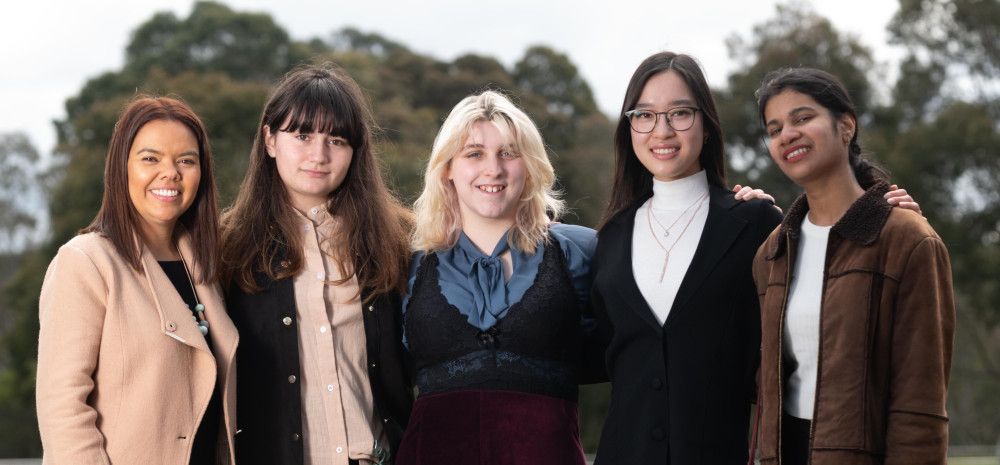 Four young women meet with Mayor Eden Foster