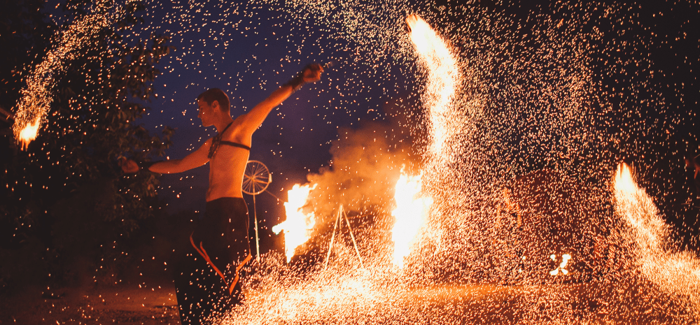 A person performing with fire in the background.