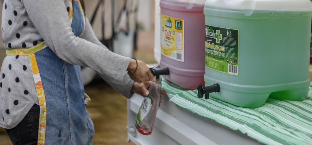 Roving Refills owner filling up their reusable container with cleaning products from a bulk container.