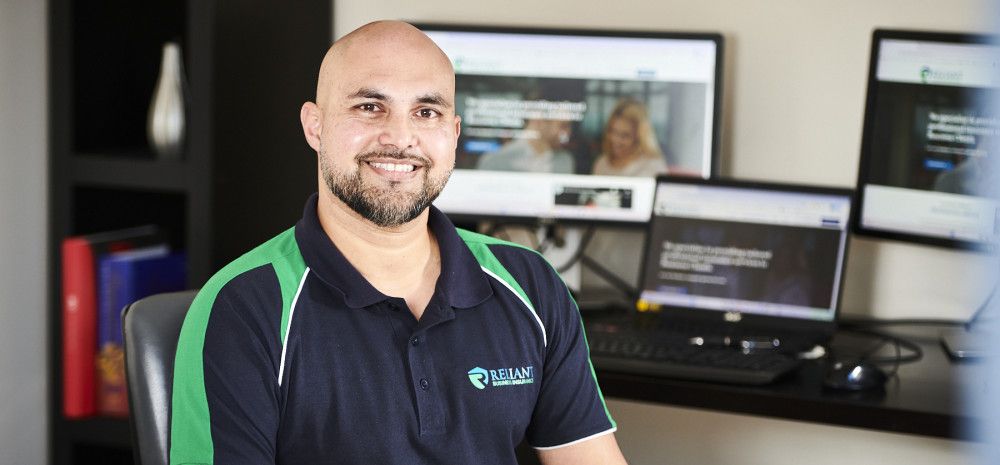 Man smiling infront of computer screens