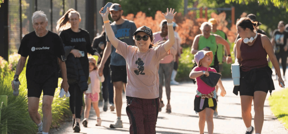 Woman running with her hands in the air, with more people following behind her