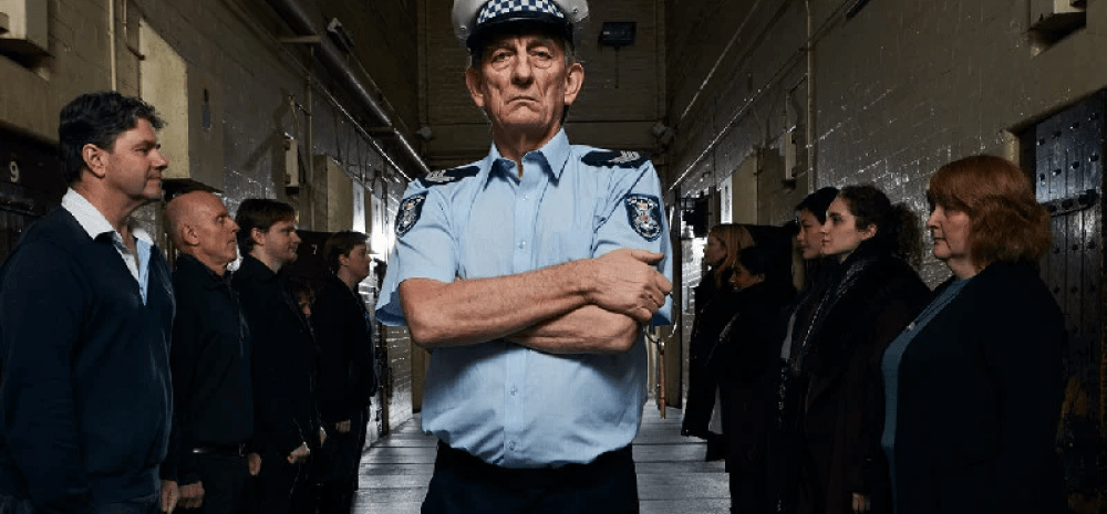 prison guard standing with crossed arms.