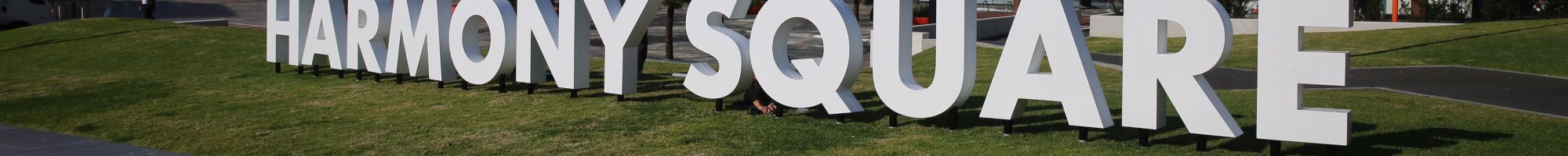 Dandenong Civic Centre with the white letters Harmony Square on the grass.