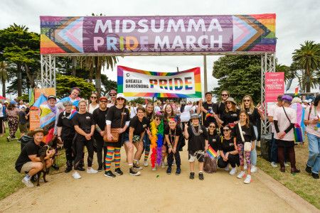 people under a midsumma banner