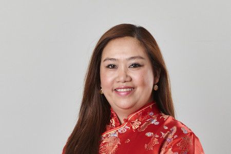 Councillor Sophie Tan in a red silk dress smiling at the camera