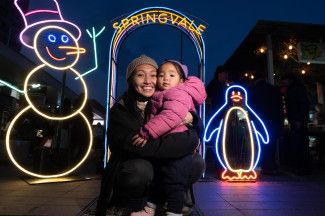 Two people posing with Neon signs