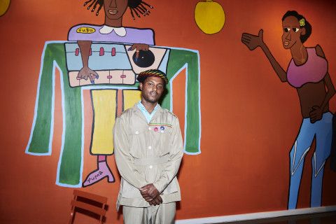 Artist stands in front of his mural