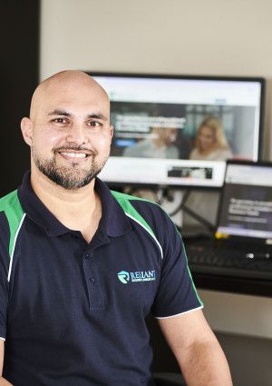 Man smiling infront of computer screens