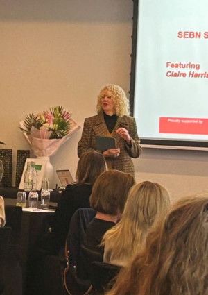 Claire Harrison standing infront of people seated at tables